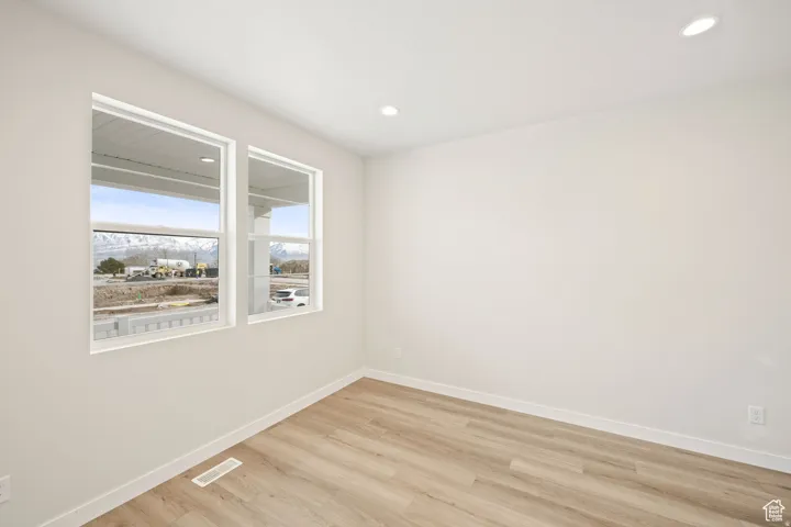 Spare room with light wood-style flooring, recessed lighting, and a mountain view