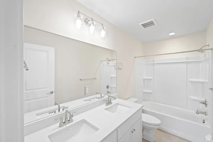 Full bathroom with double vanity and bathing tub / shower combination