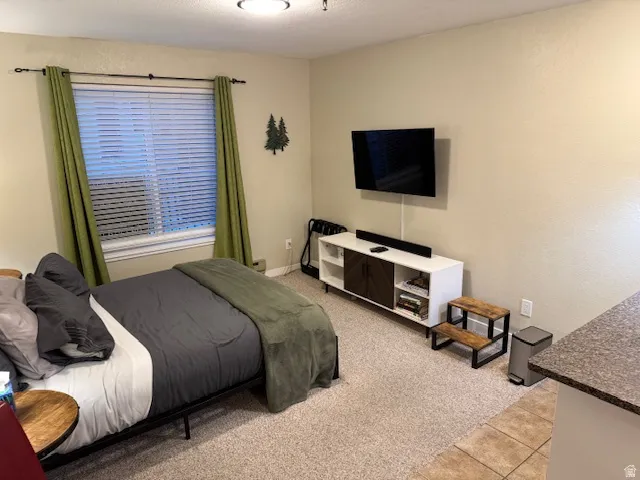 Bedroom featuring light colored carpet and light tile patterned floors