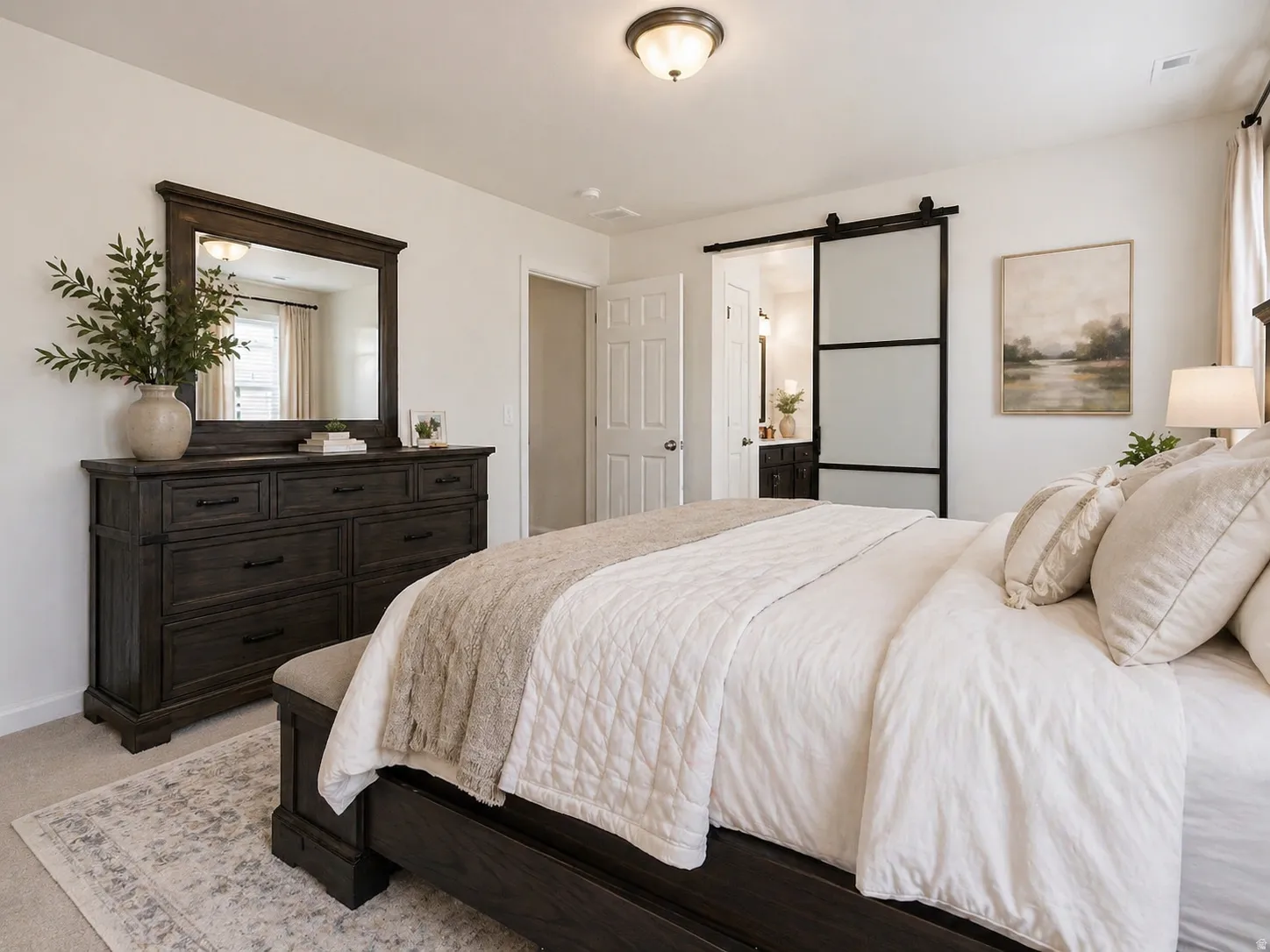 Bedroom with a barn door and connected bathroom