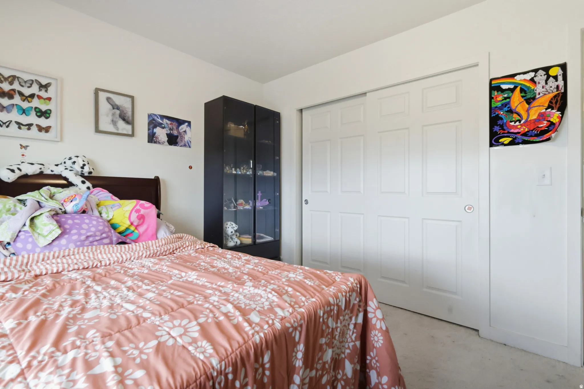 Bedroom with light carpet and a closet