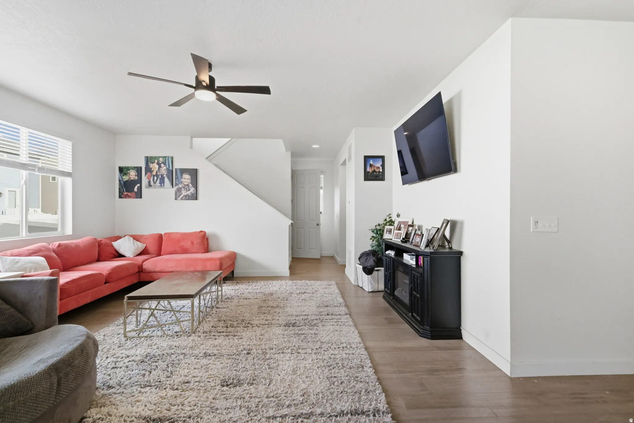 Living room with wood finished floors and a ceiling fan