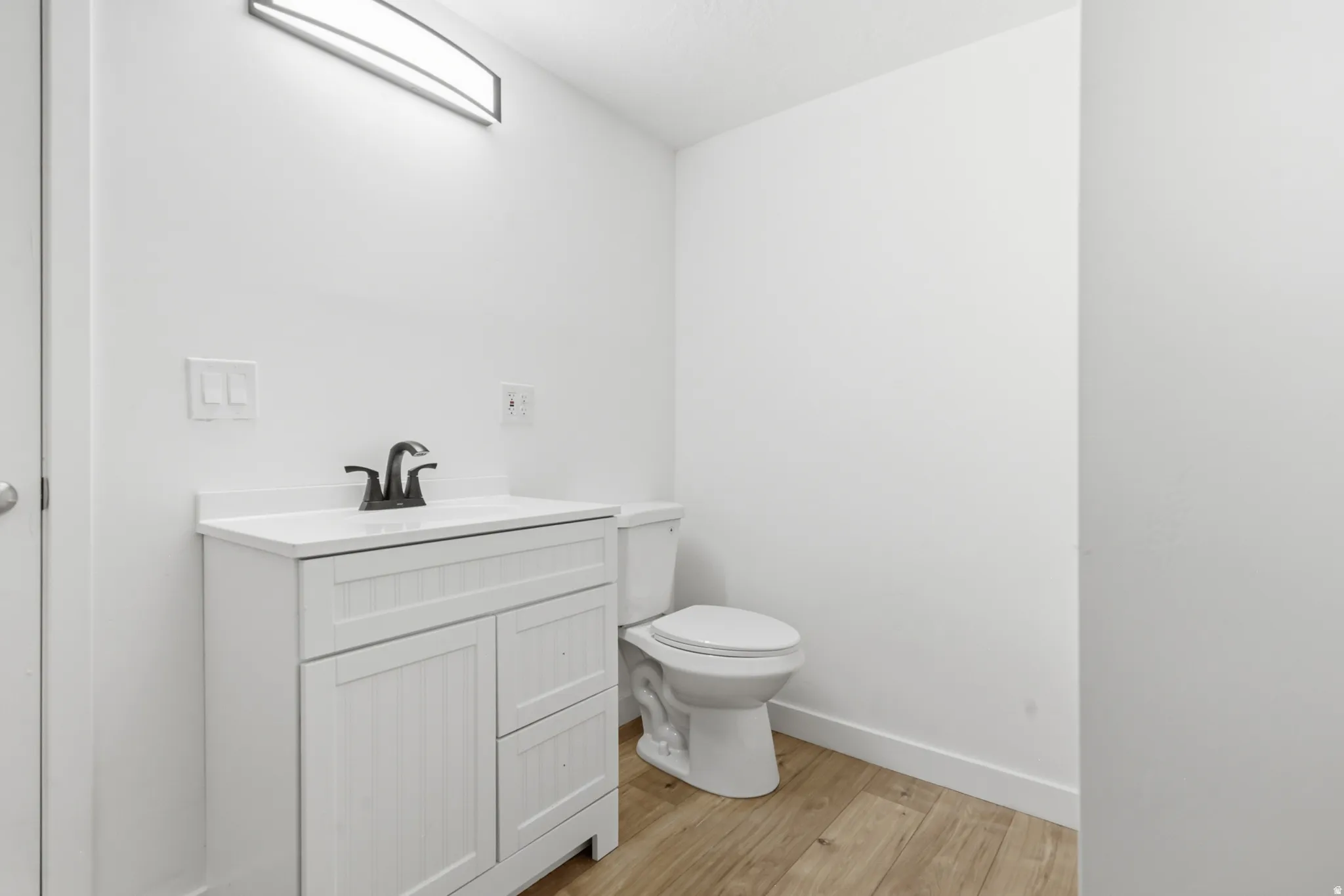 Full bath featuring vanity and light wood-style floors