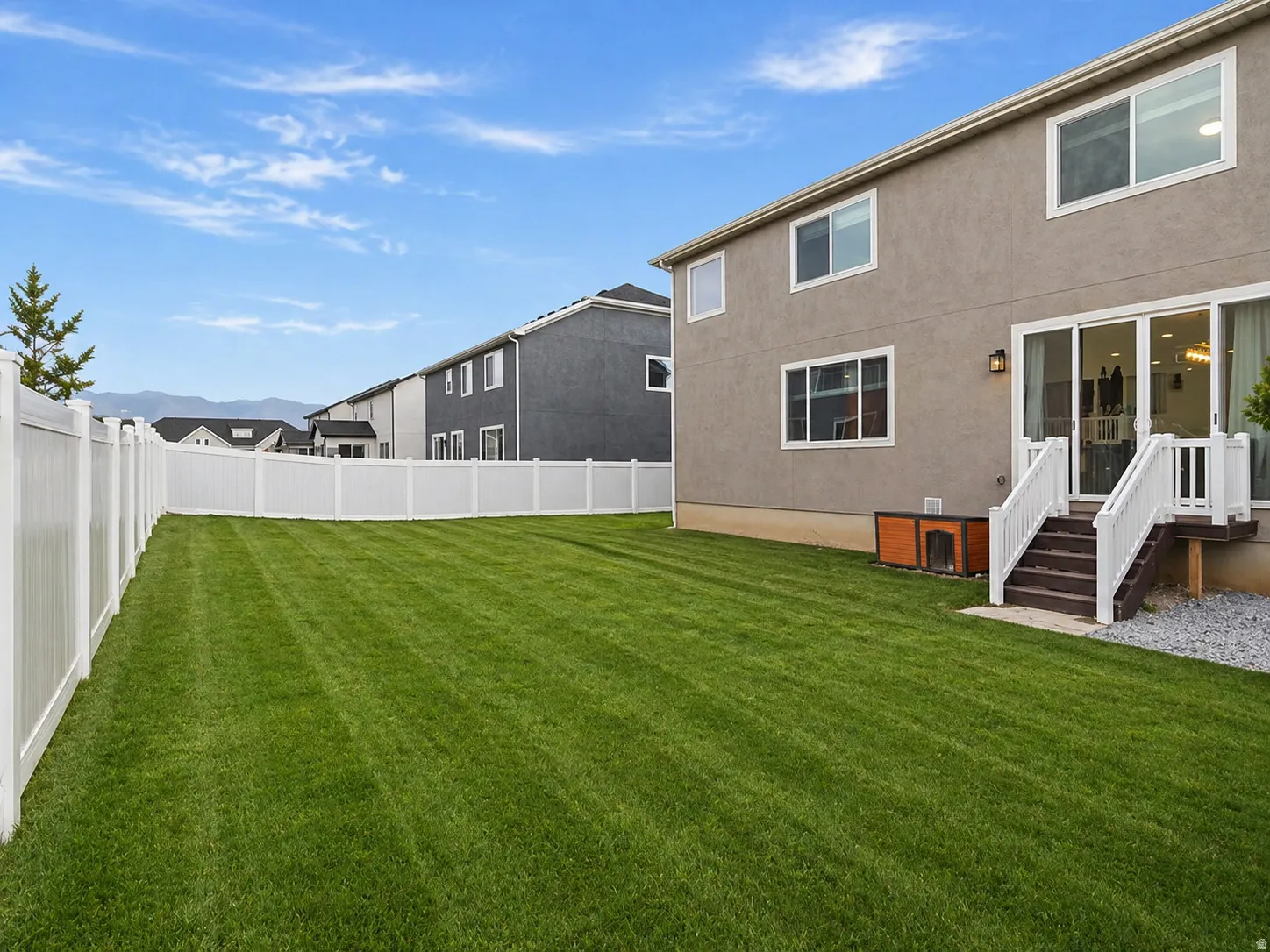 Back of property with a fenced backyard and stucco siding