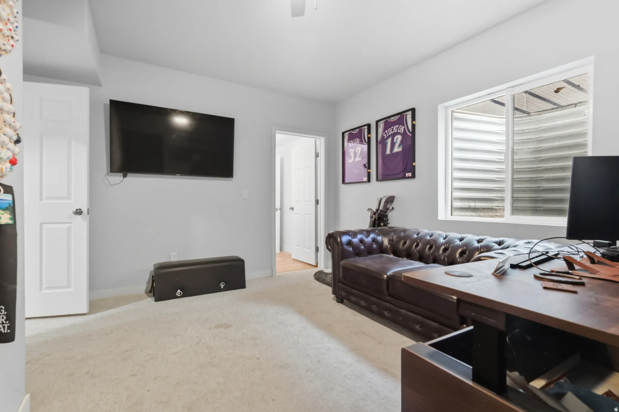 Bedroom/office with light carpet and baseboards