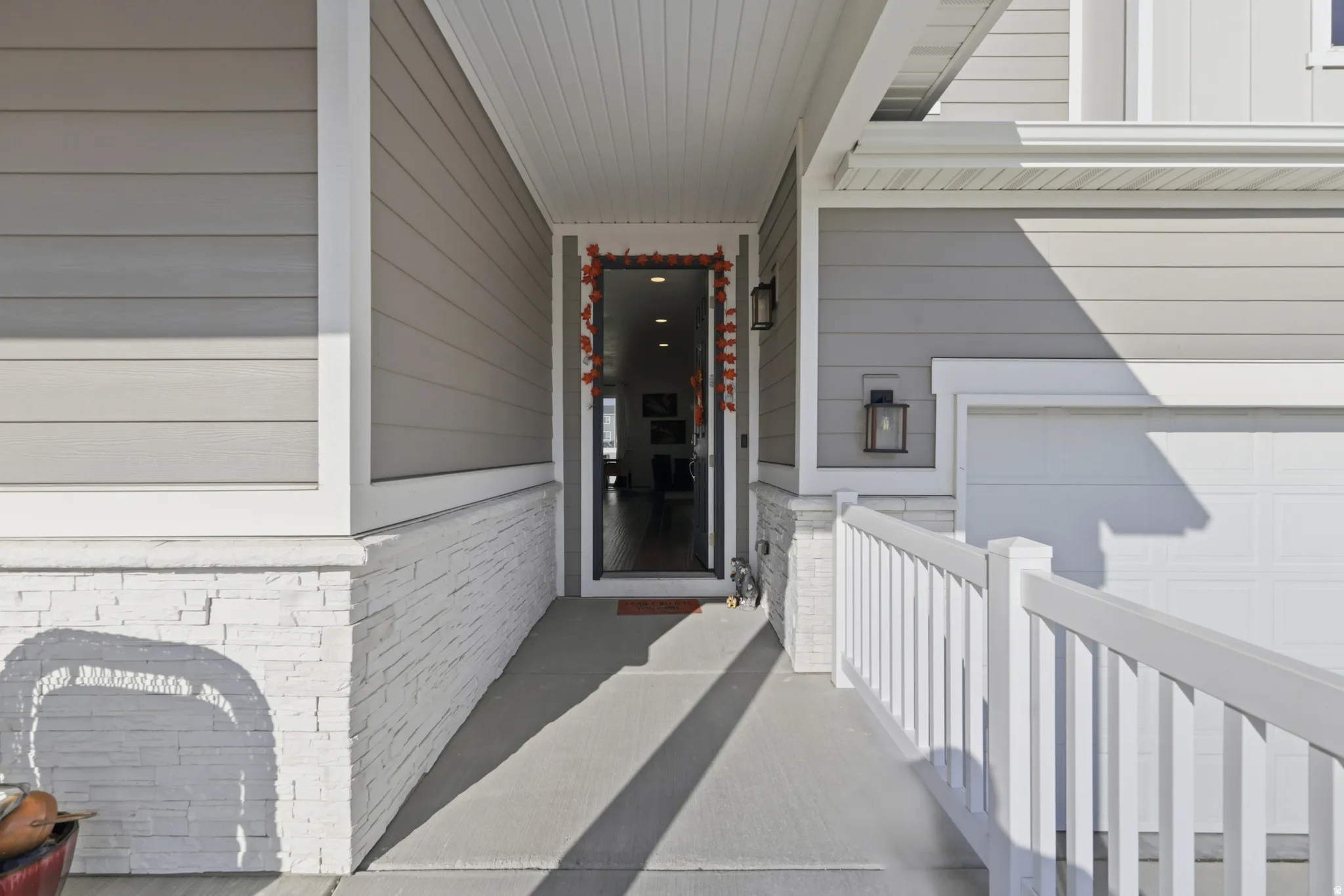 View of exterior entry featuring covered porch and stone siding