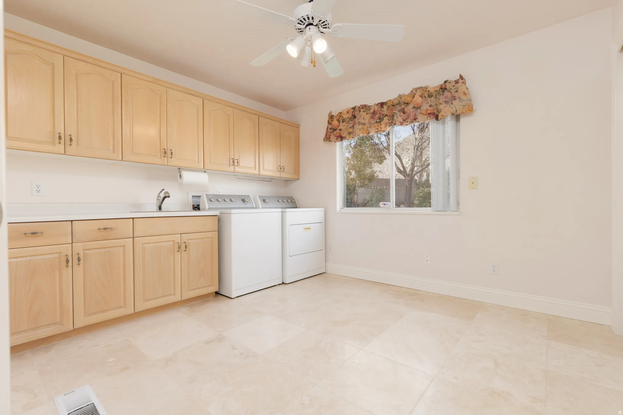 Laundry area featuring ceiling fan, cabinet space, and washer and clothes dryer