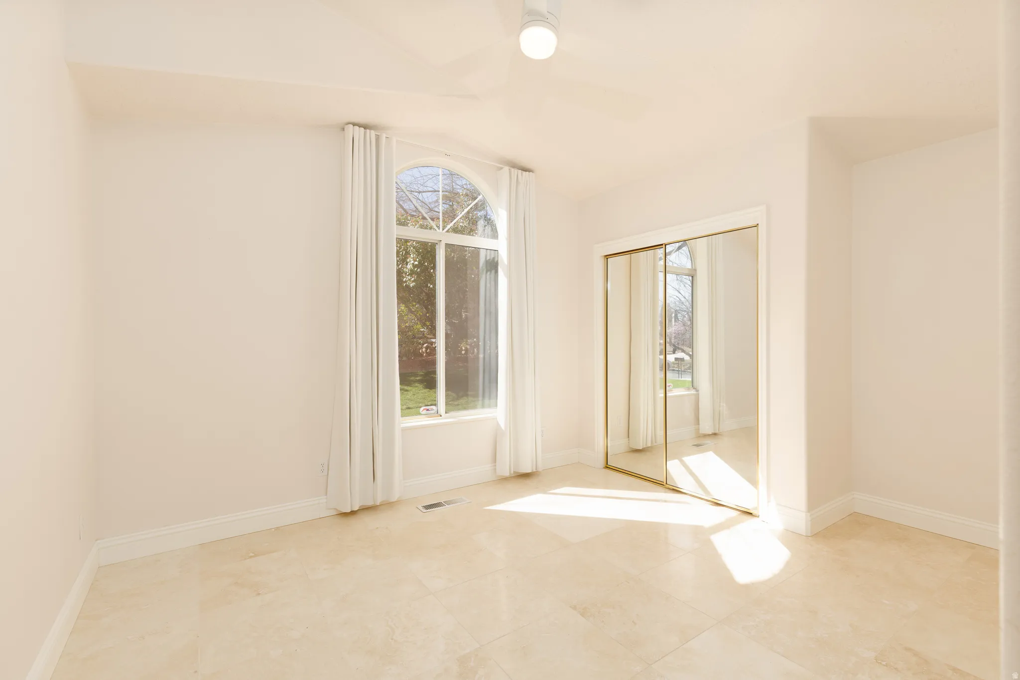 Spare room with baseboards and vaulted ceiling
