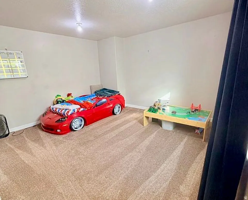 Bedroom featuring a textured ceiling and carpet