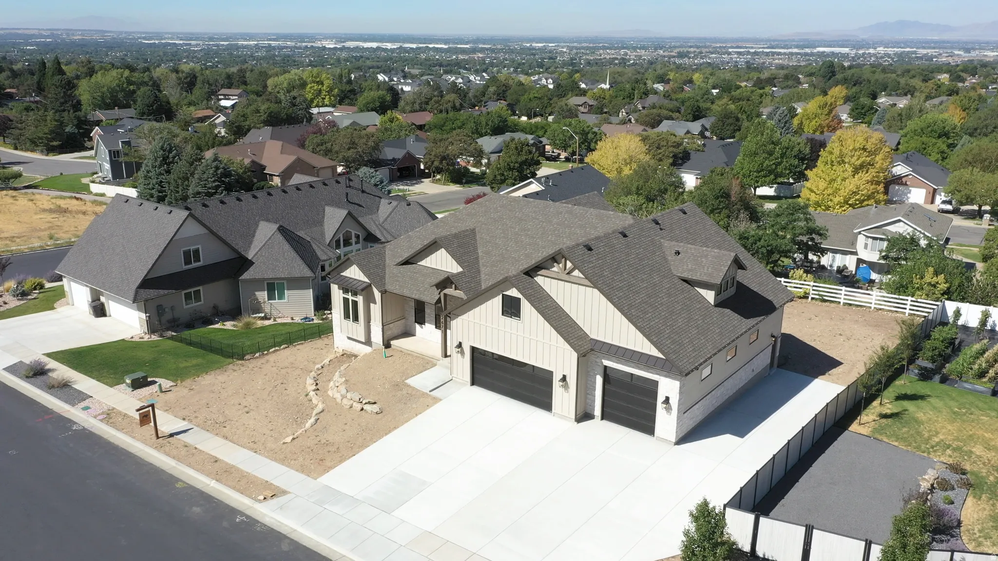 Contemporary residence featuring multiple gables, an attached three-car garage, and a concrete driveway