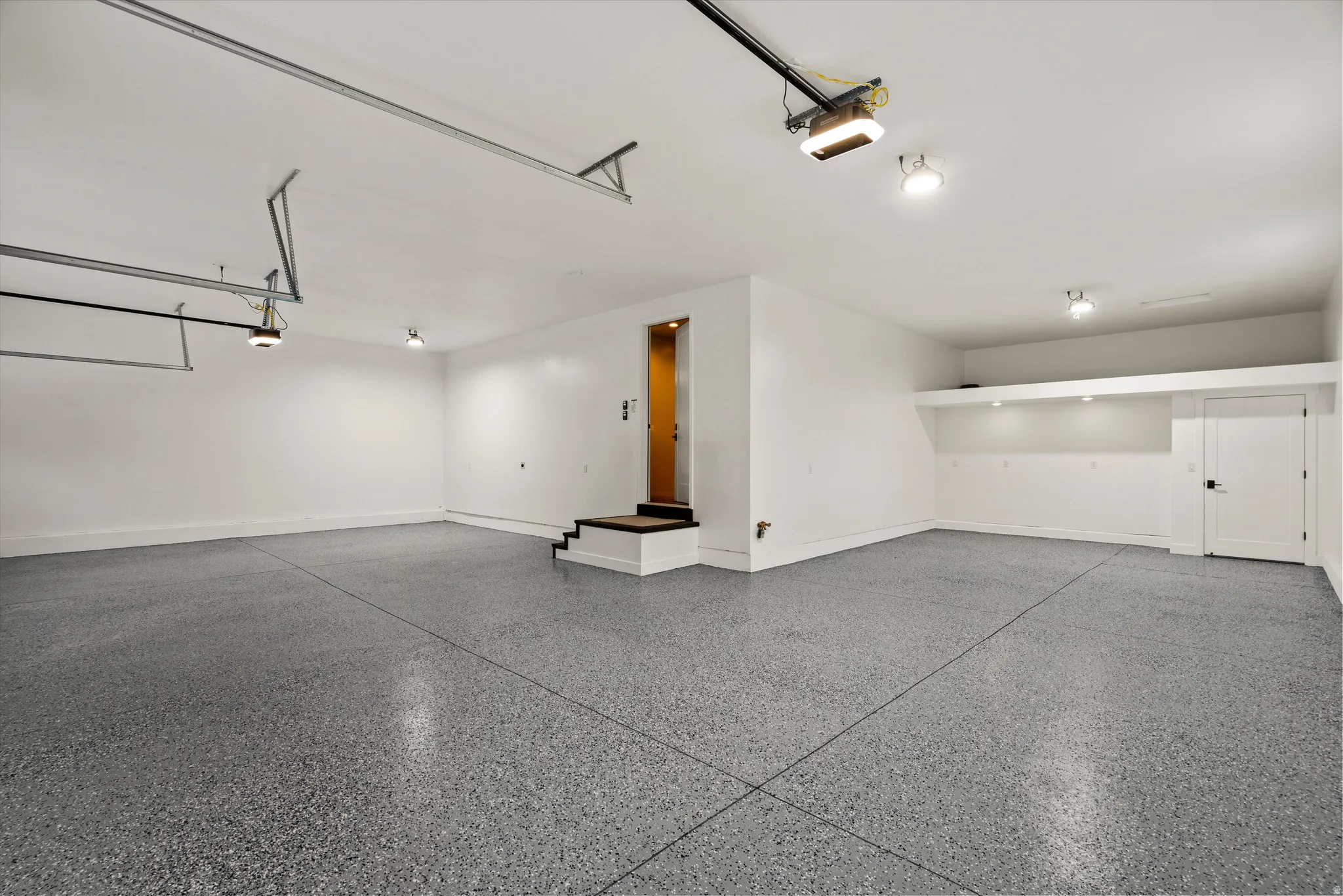 Garage with baseboards and a garage door opener