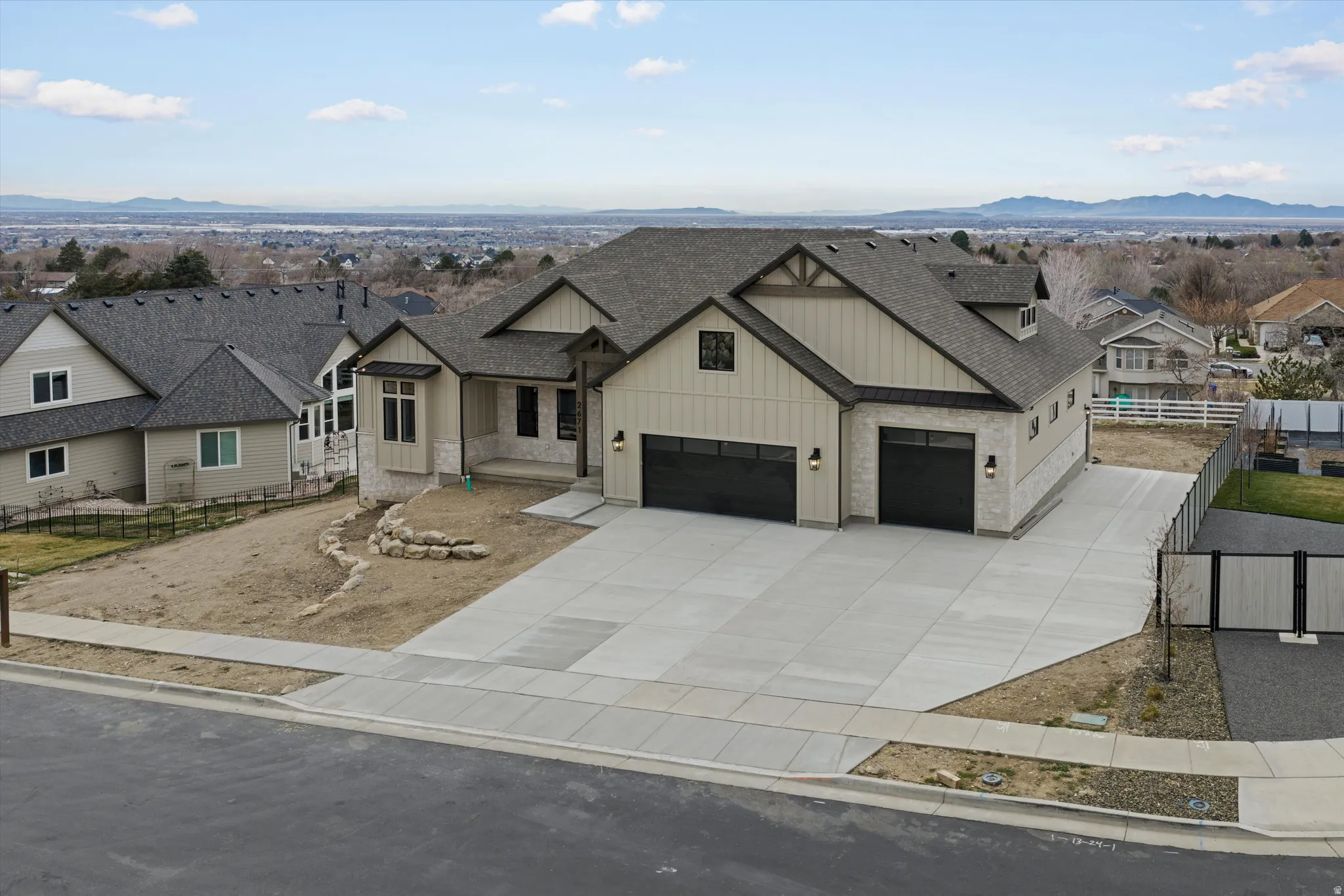 Modern inspired farmhouse featuring board and batten siding, a residential view, a mountain view, a shingled roof, and driveway