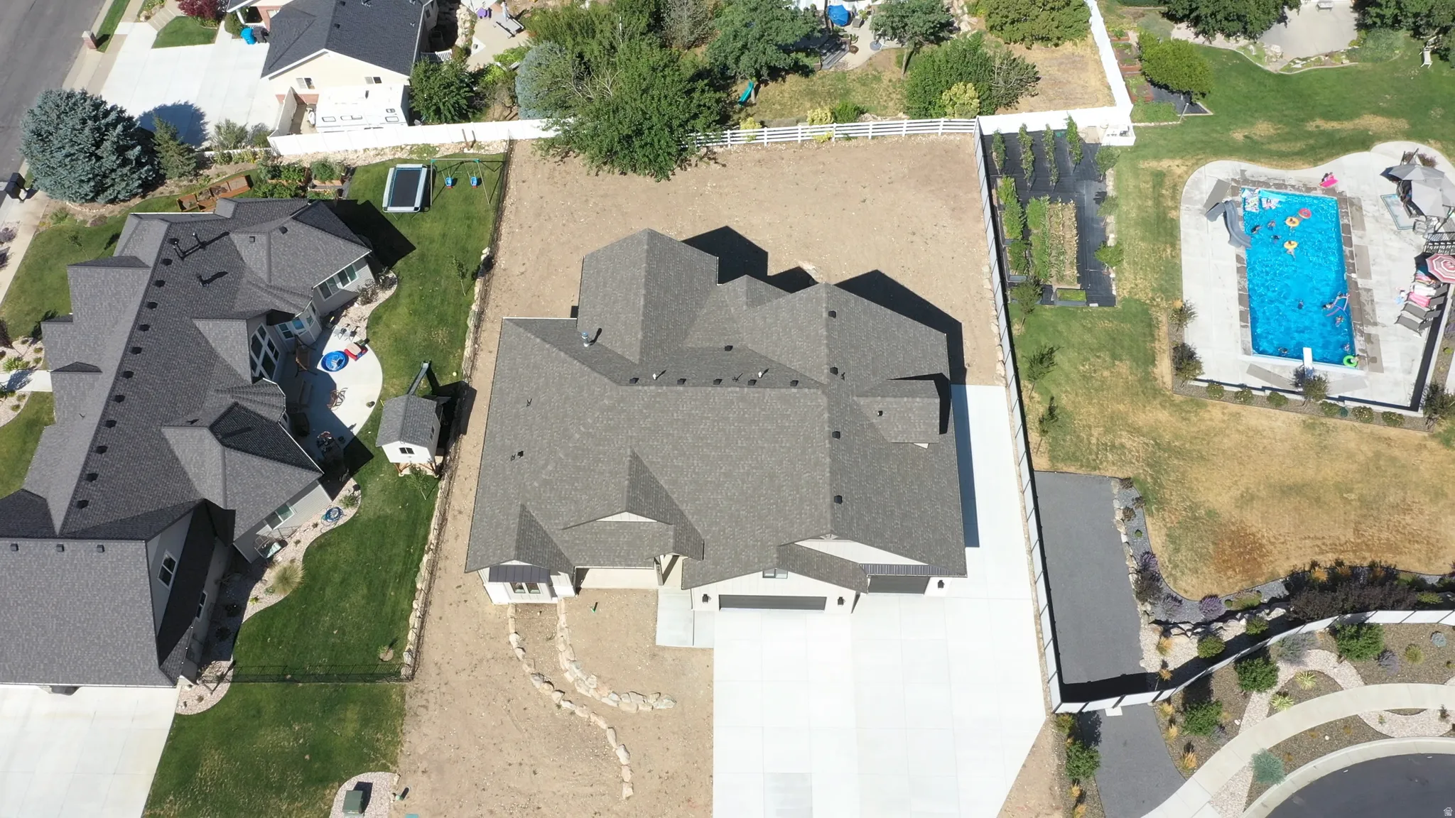 Expansive property featuring a multi-gabled roofline, concrete driveway, and a spacious rear lot