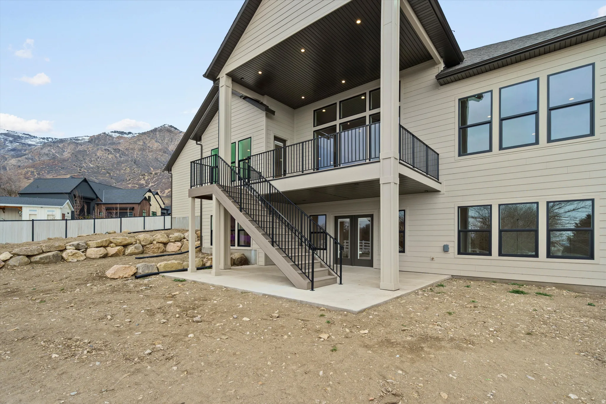 Rear view of property with a patio, a mountain view, french doors, and a balcony