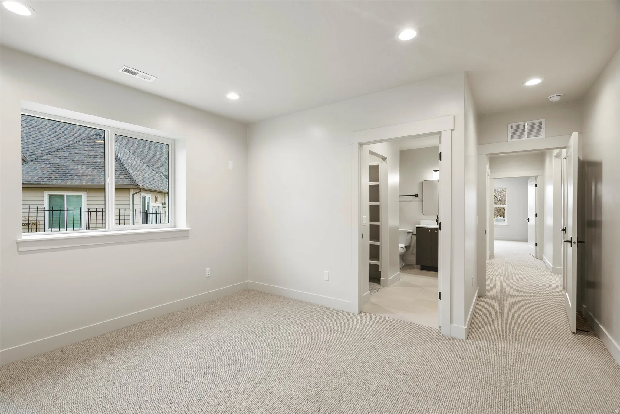 Unfurnished bedroom with light carpet, recessed lighting, and connected bathroom