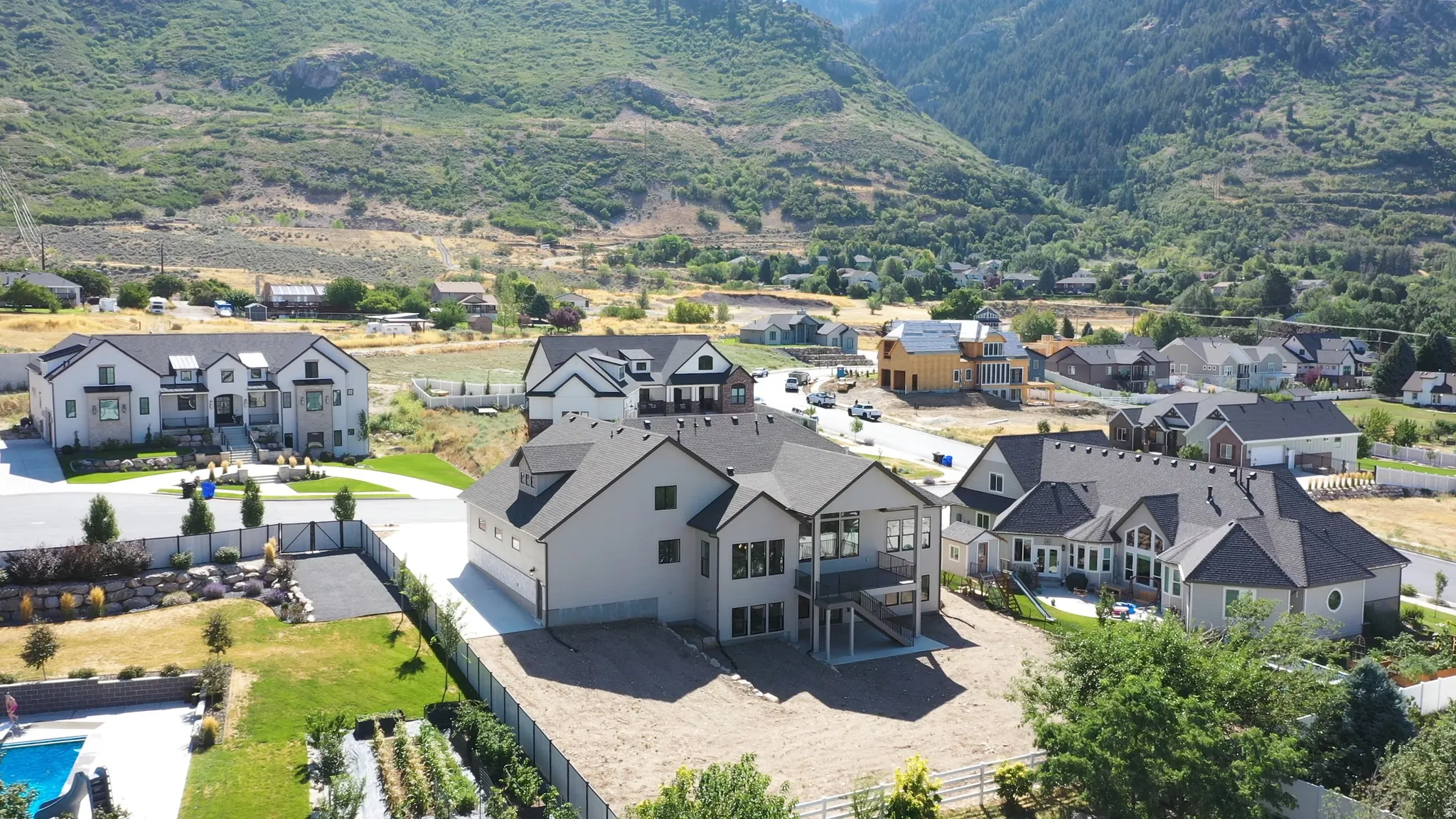 Contemporary two-story residence with a multi-level deck, dark shingle roofing, and light-toned siding