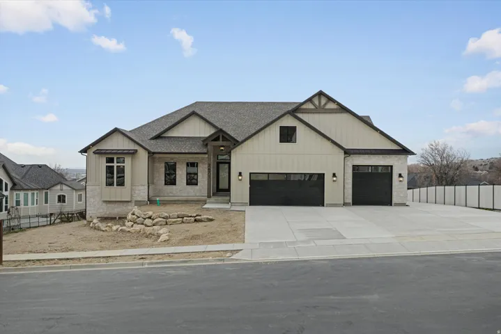 Modern farmhouse style home with board and batten siding, roof with shingles, concrete driveway, and an attached garage