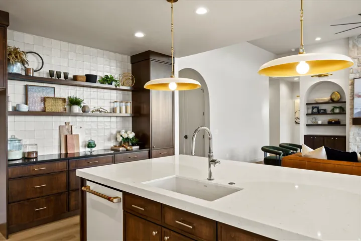 Kitchen with dark wood finish cabinetry, dark stone countertops, open shelves, and built in shelves