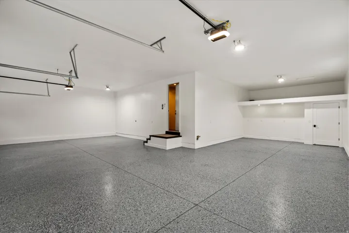 Garage with baseboards and a garage door opener