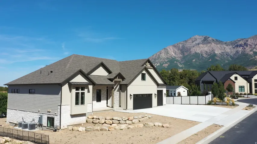 Contemporary residence featuring a multi-tone exterior, dark-framed windows, an attached two-car garage, and a concrete driveway