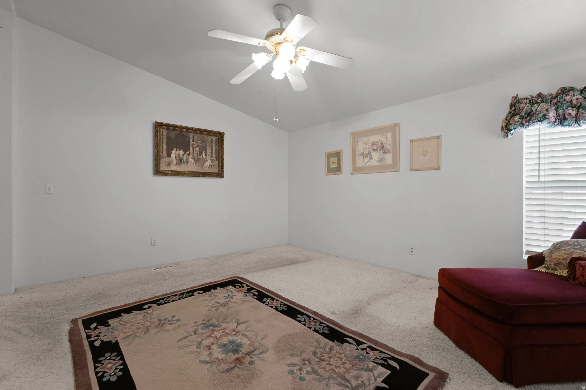Sitting room featuring ceiling fan, carpet, and lofted ceiling