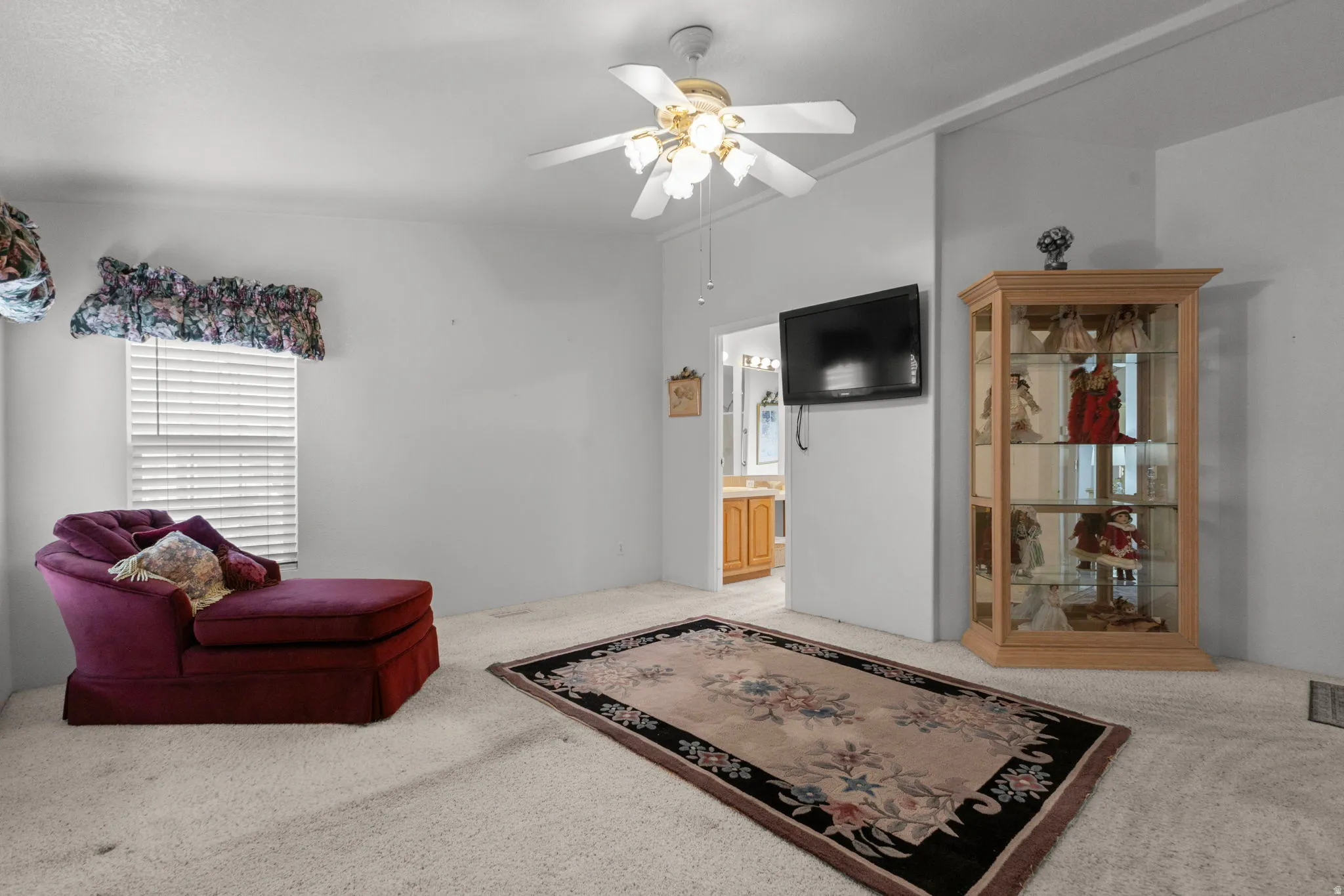 Sitting room featuring light carpet and a ceiling fan