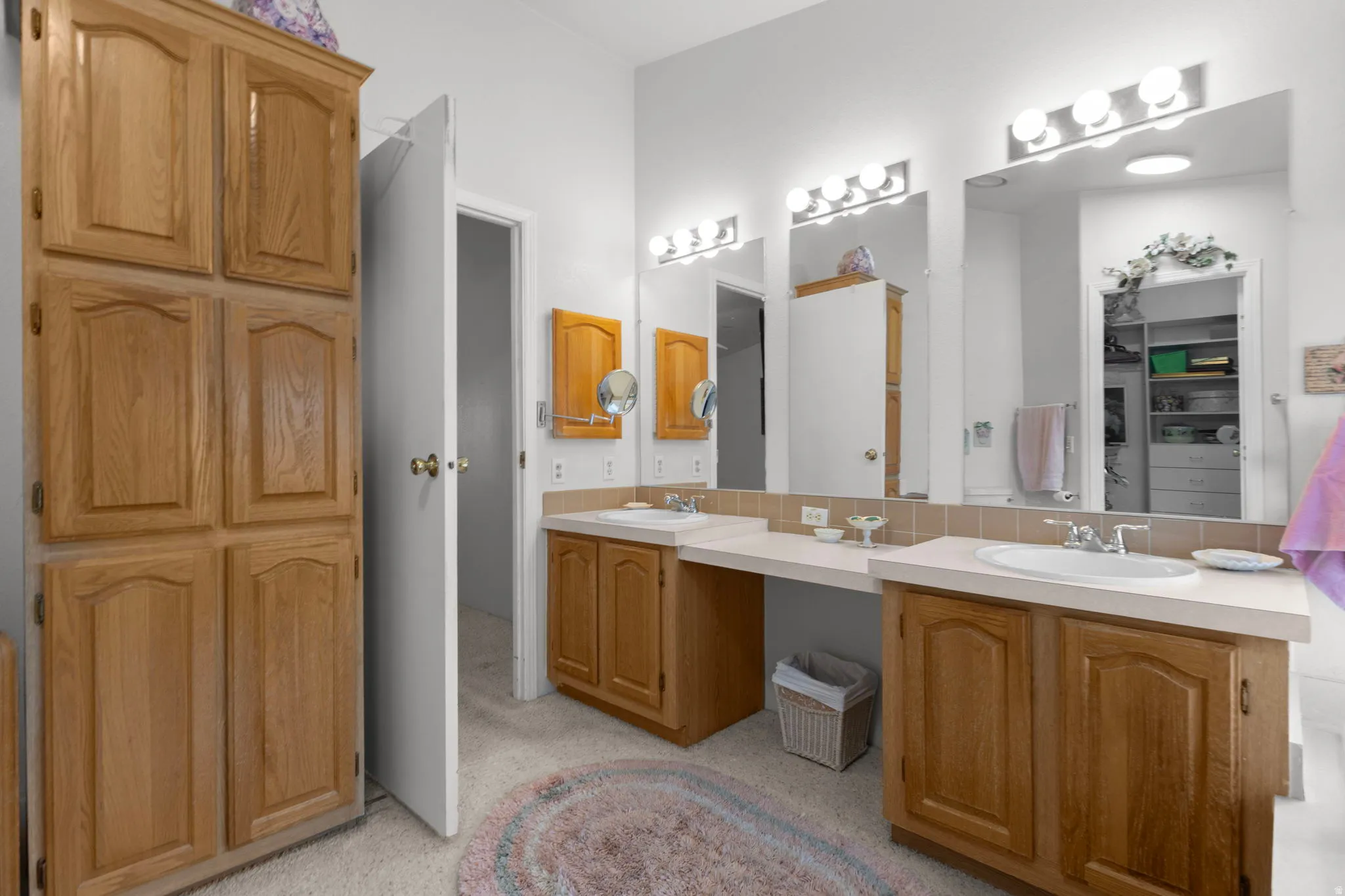 Full bath featuring double vanity, decorative backsplash, and a spacious closet