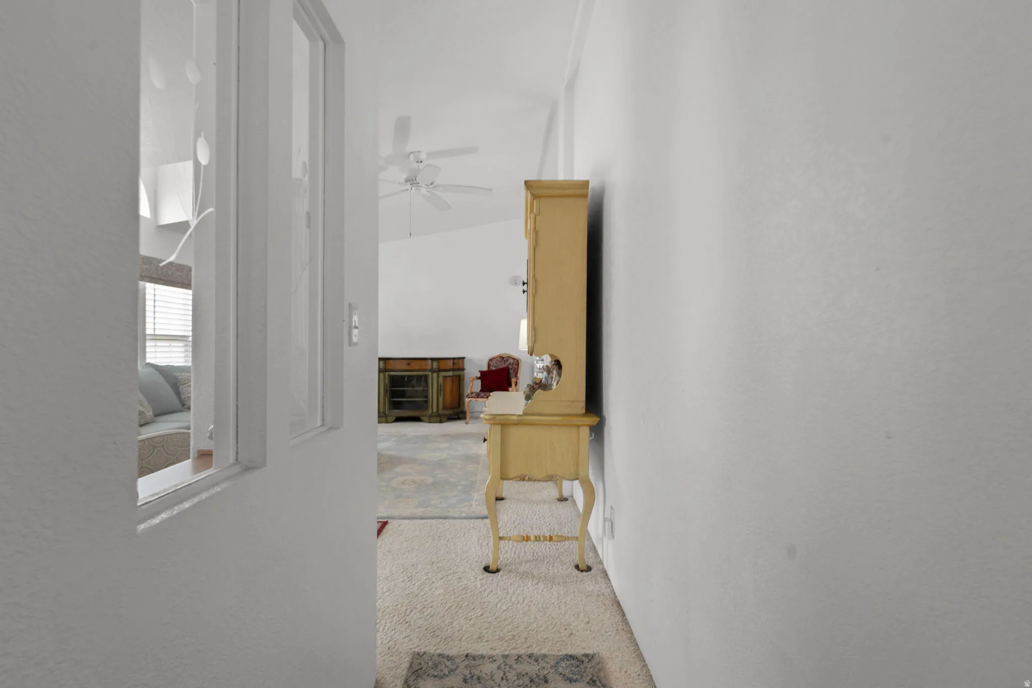 Corridor with light colored carpet and a textured wall