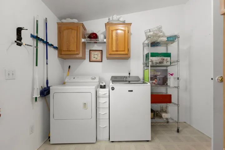 Laundry room with light flooring, washer and clothes dryer, and cabinet space