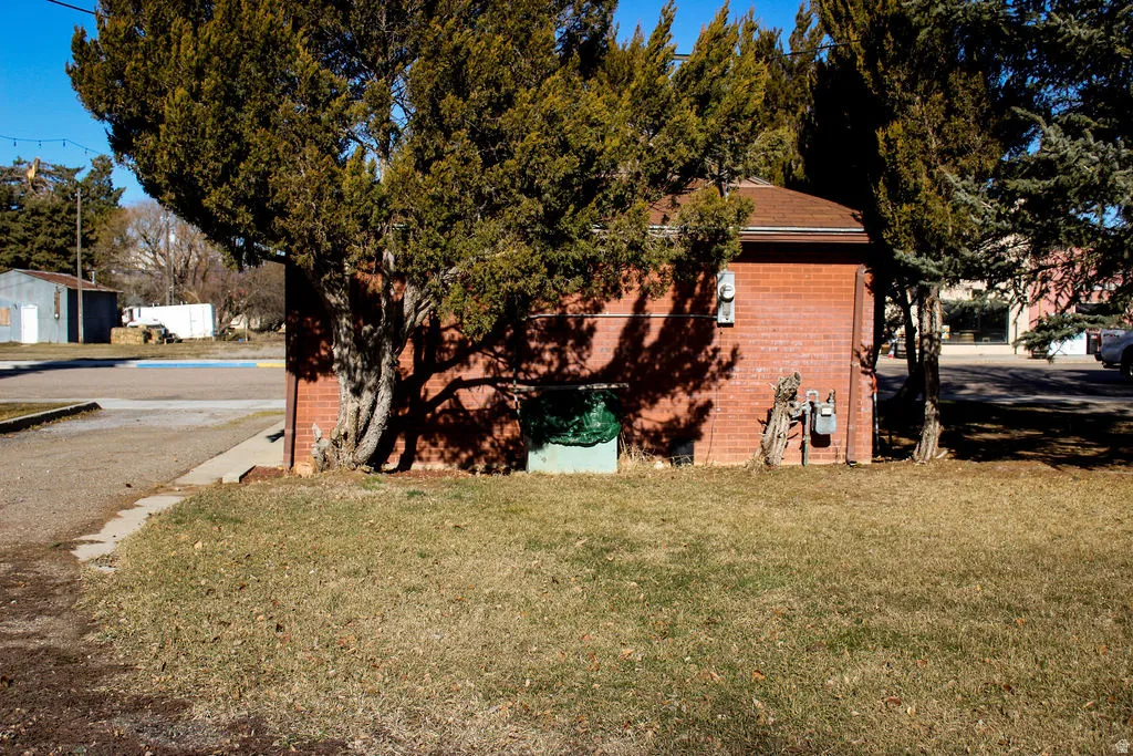 View of side of home with a yard and brick siding
