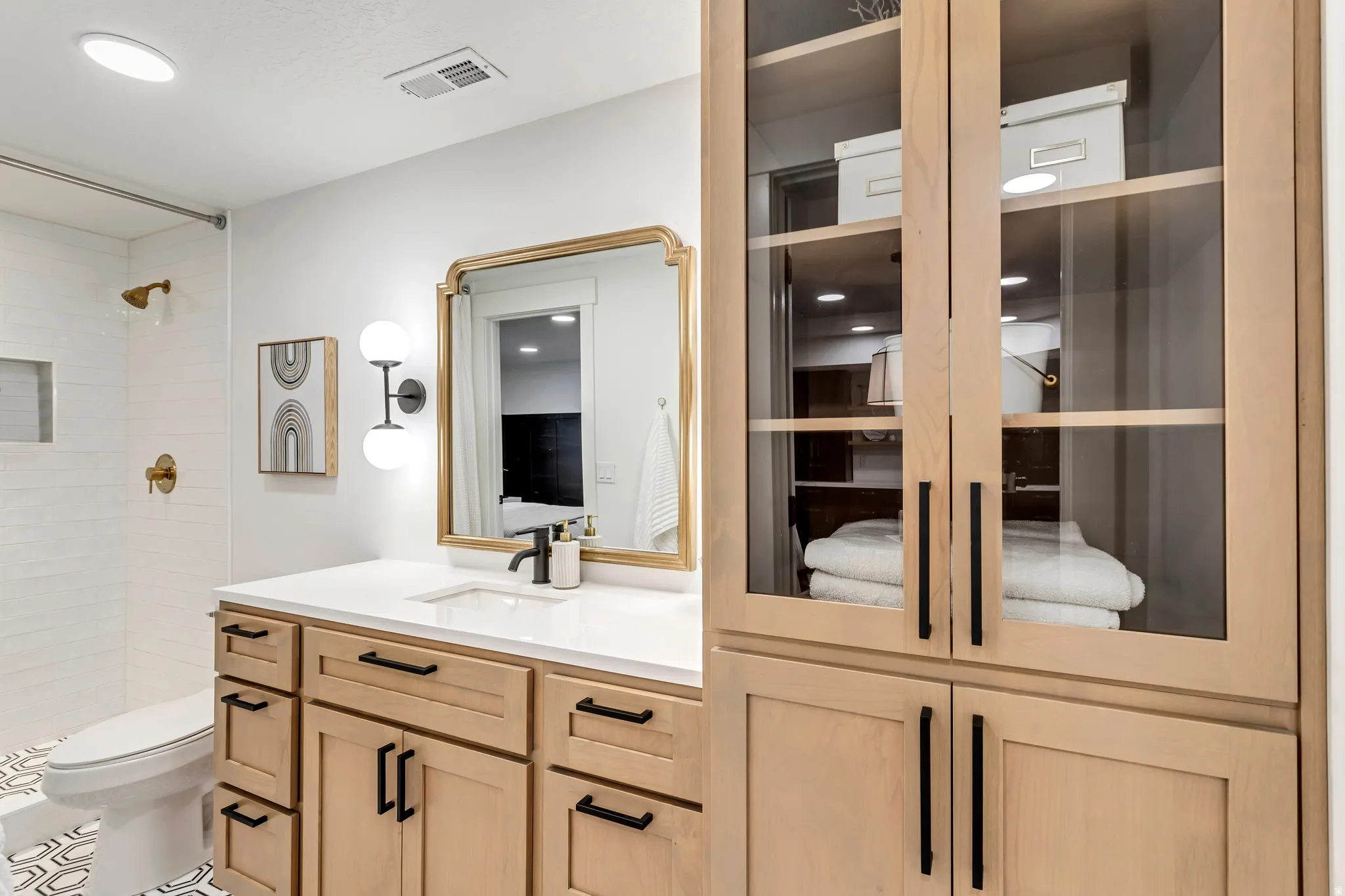 Bathroom featuring vanity, a tile shower, and tile patterned floors