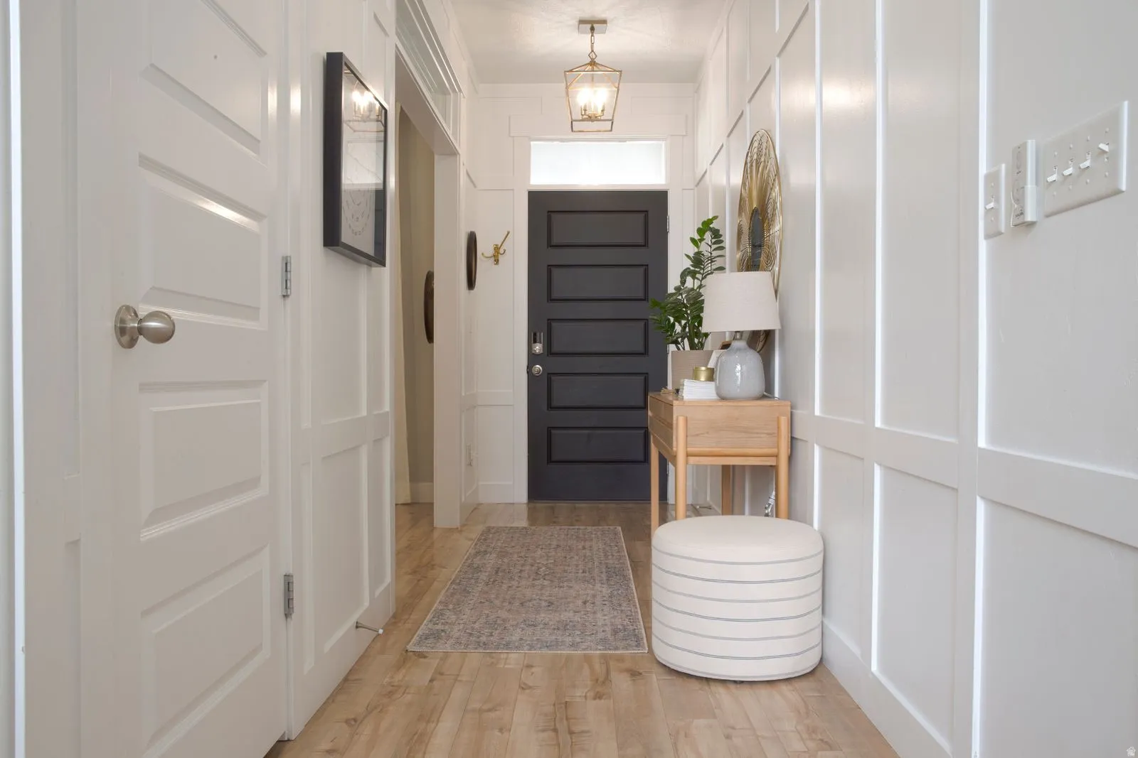 Foyer entrance with a decorative wall and light wood-type flooring