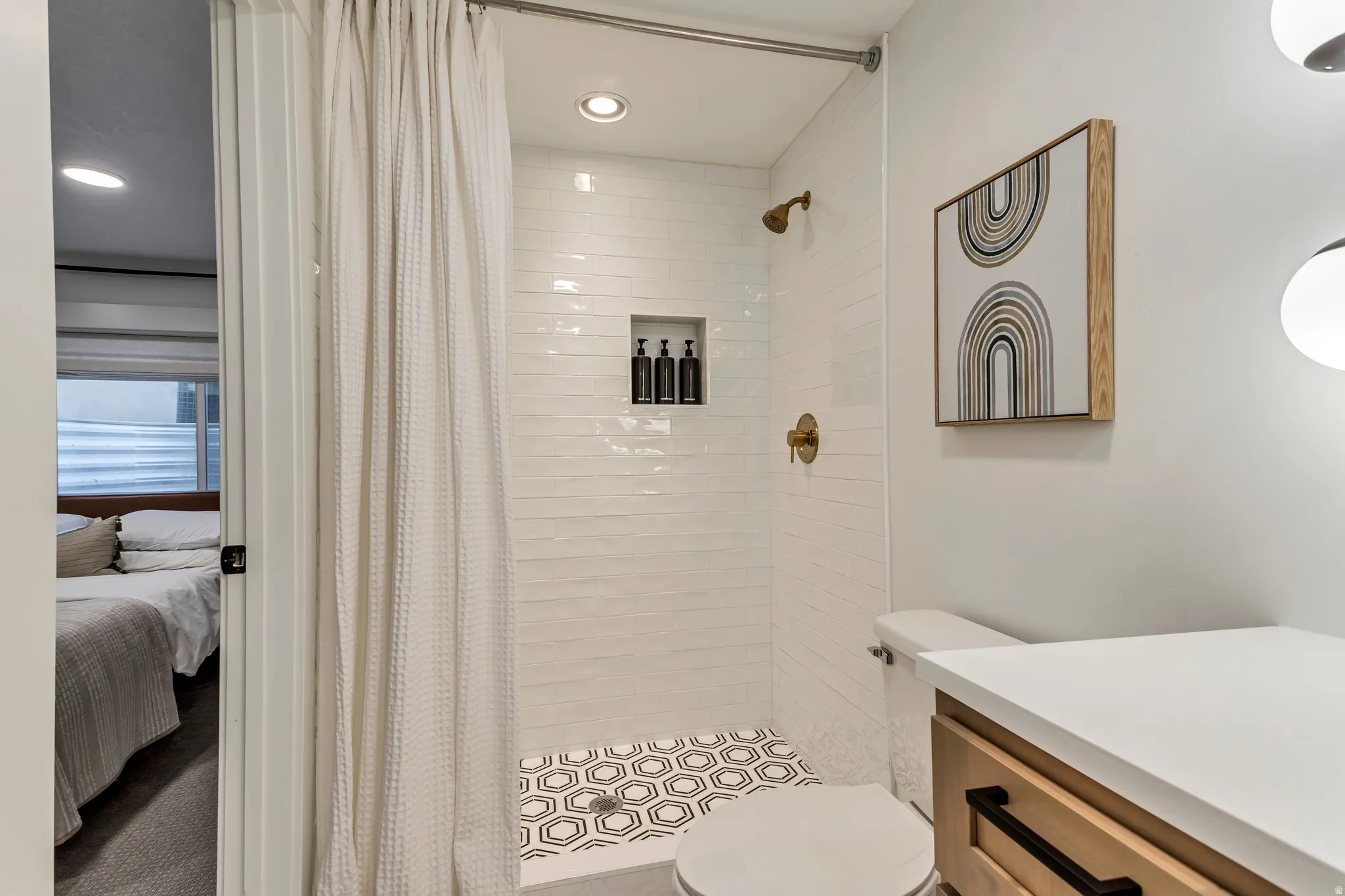 Ensuite bathroom with a shower stall, vanity, and recessed lighting