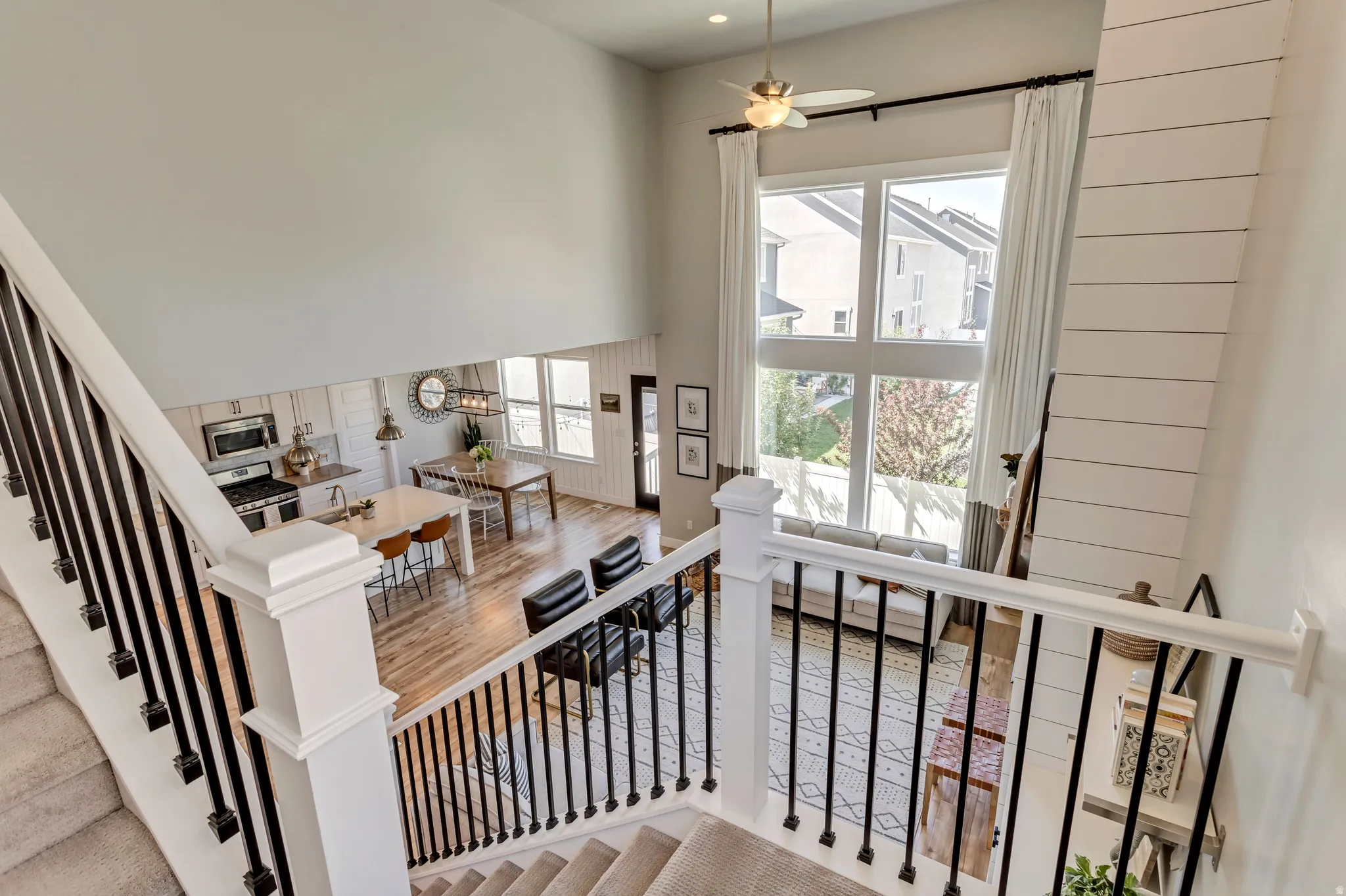 Stairs featuring a high ceiling, ceiling fan, and wood finished floors