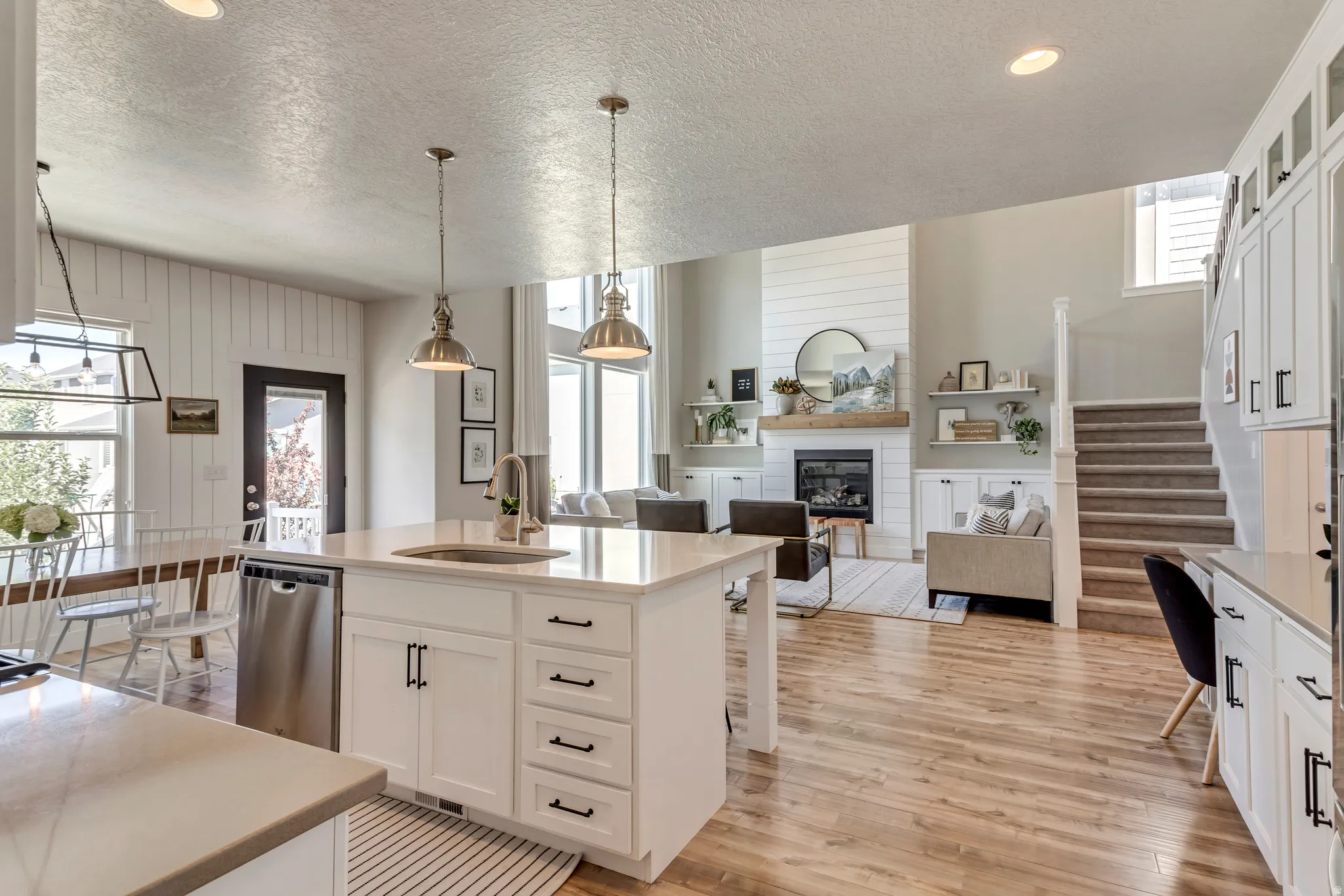 Kitchen featuring open floor plan, plenty of natural light, white cabinets, and a kitchen island with sink