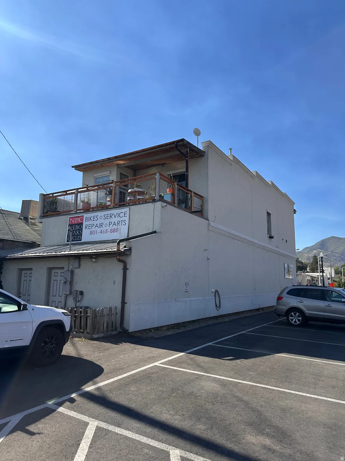 View of building exterior featuring a mountain view and uncovered parking