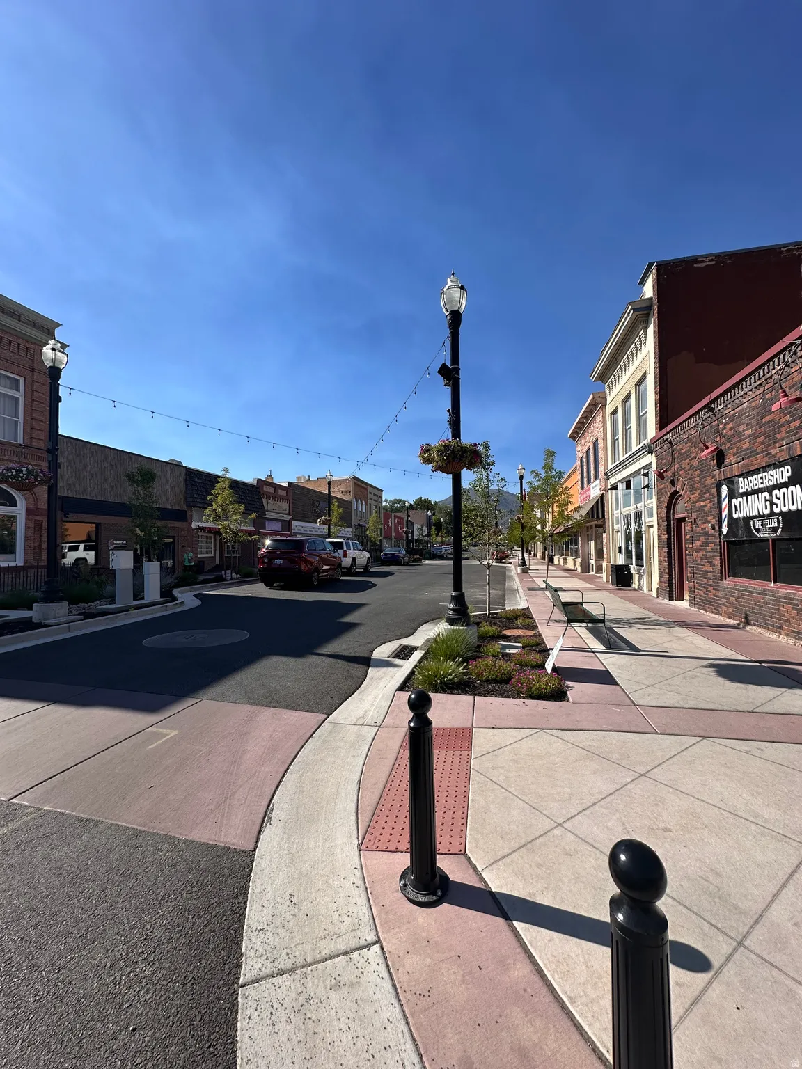 View of asphalt street with street lighting, sidewalks, and curbs