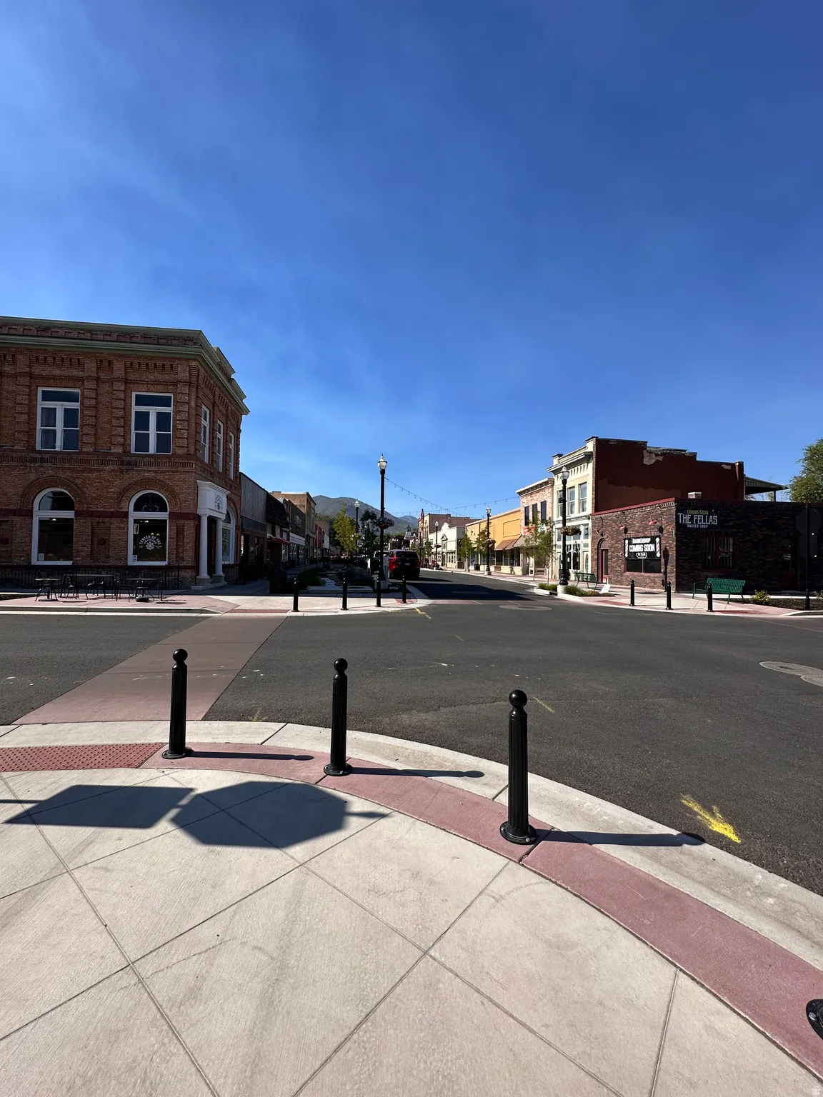 View of asphalt street with sidewalks, curbs, and street lighting