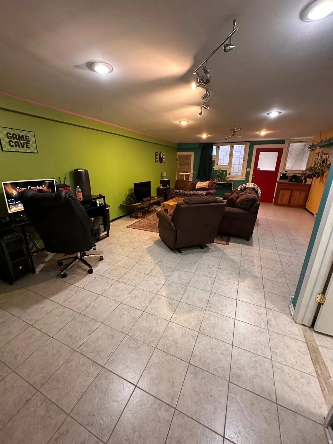 Living area featuring a desk, light tile patterned floors, and track lighting