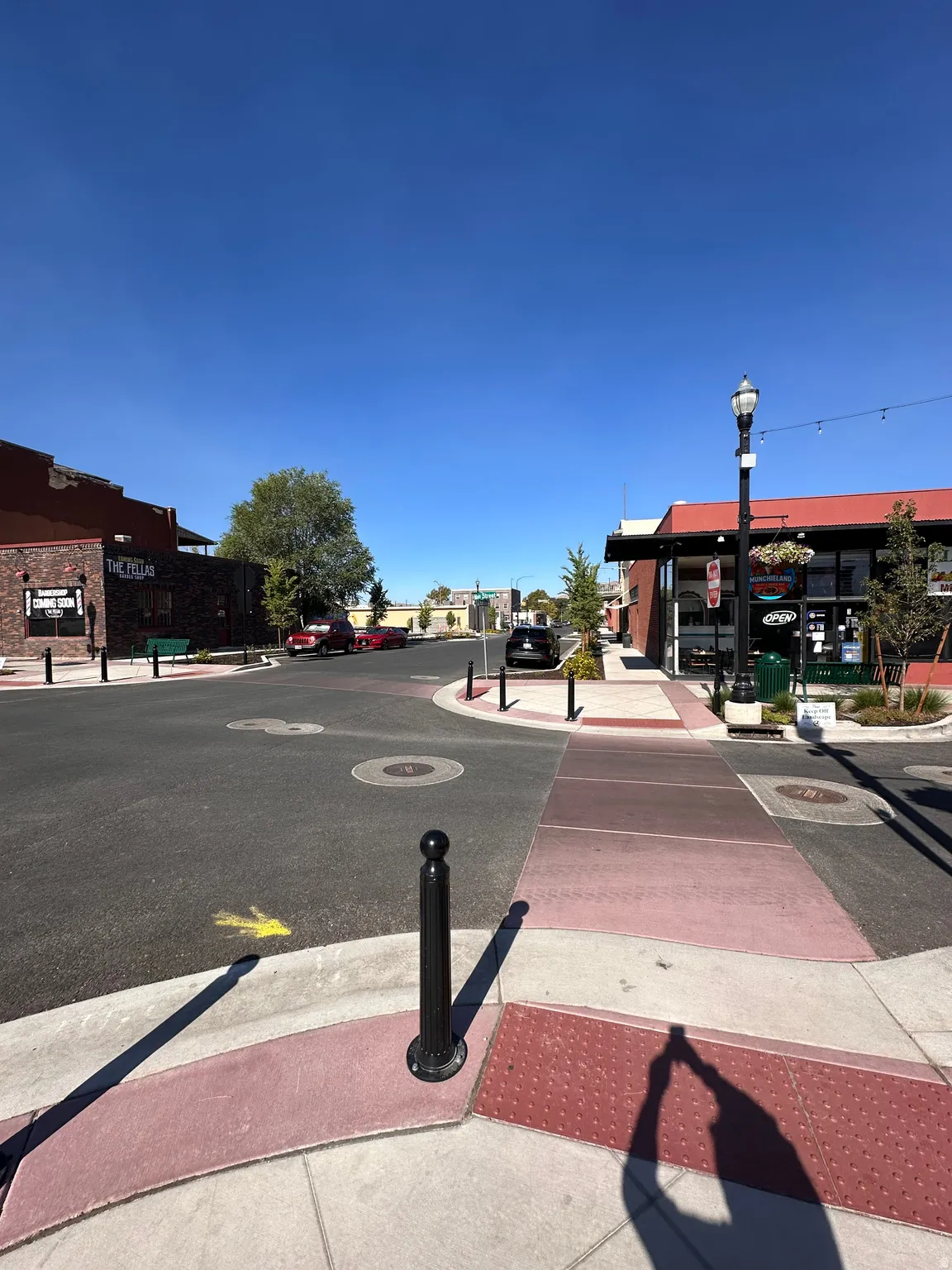View of asphalt street with curbs, sidewalks, and street lighting