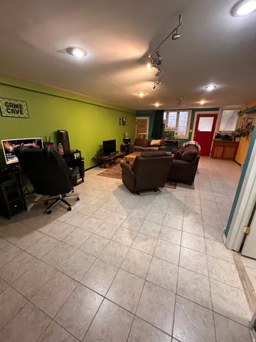 Living area featuring a desk, light tile patterned floors, and track lighting