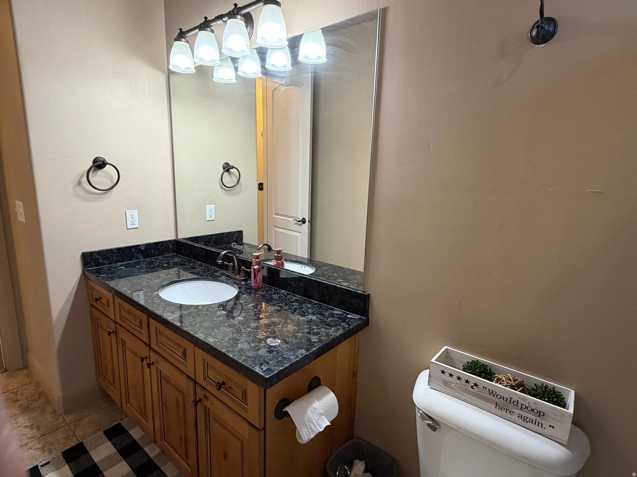 Half bathroom featuring vanity and light tile patterned floors