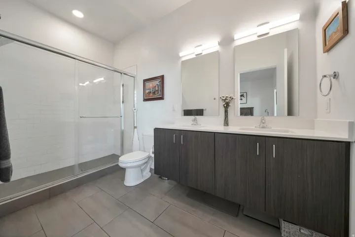 Bathroom with double vanity, a stall shower, and recessed lighting