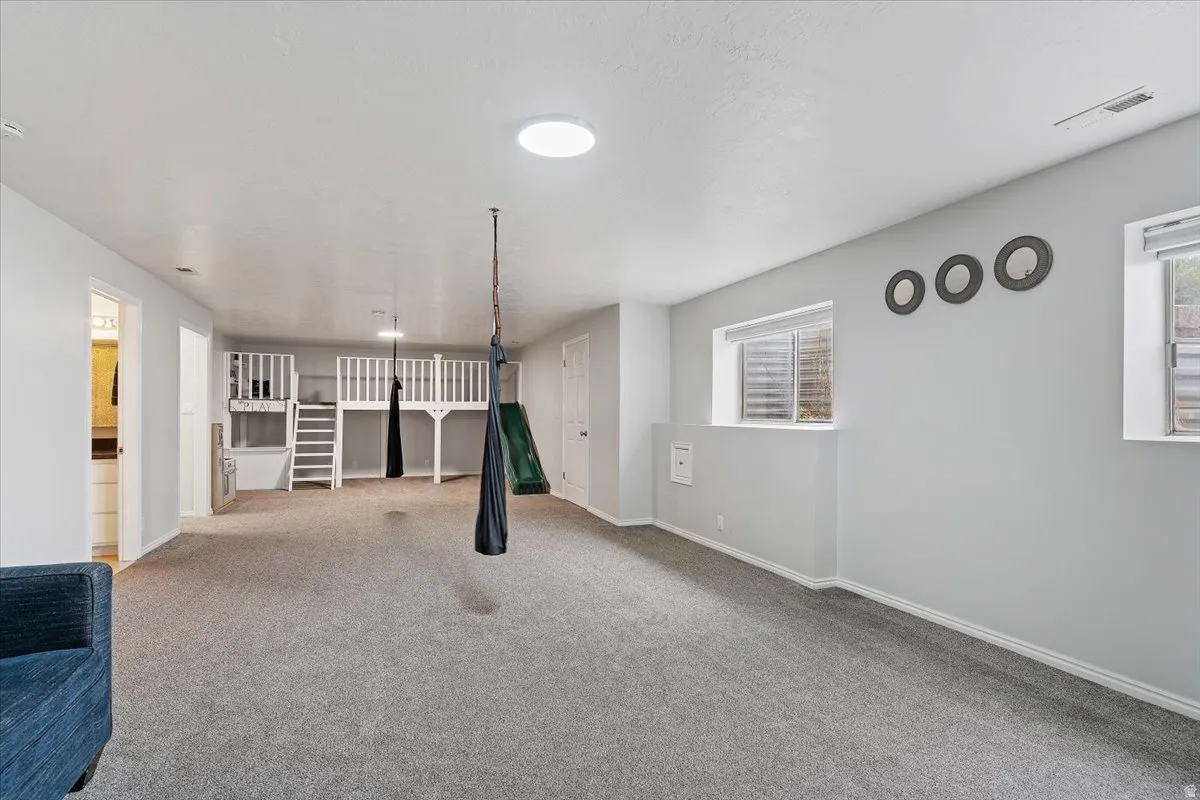 Unfurnished living room featuring carpet floors and baseboards