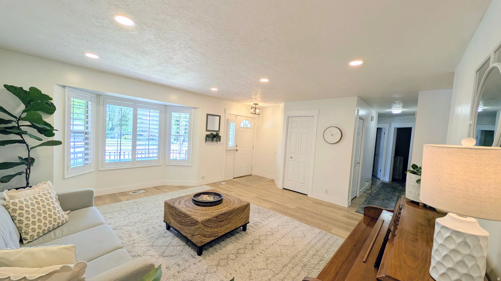 Open-concept living space with recessed lighting and light wood-finish flooring