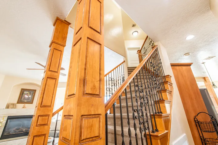 Stairway featuring a tiled fireplace, a textured ceiling, recessed lighting, and ceiling fan