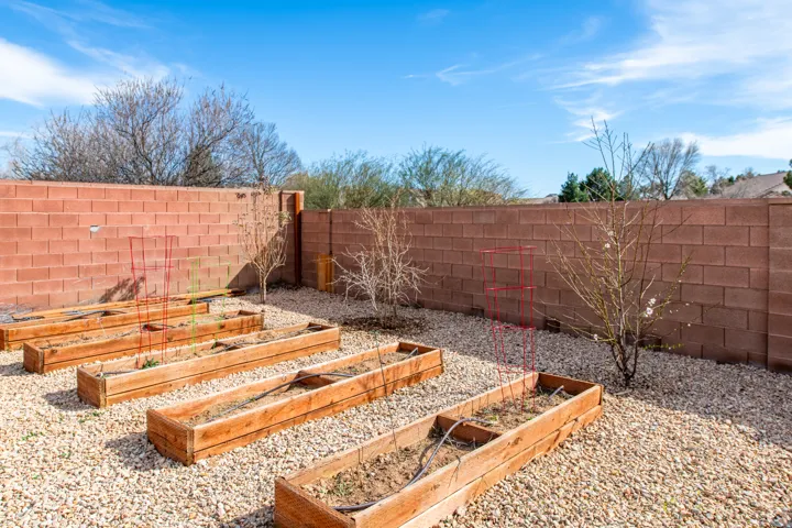 Fenced backyard featuring a vegetable garden