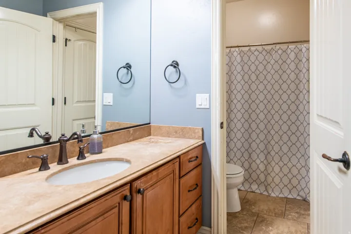 Full bath featuring curtained shower and vanity