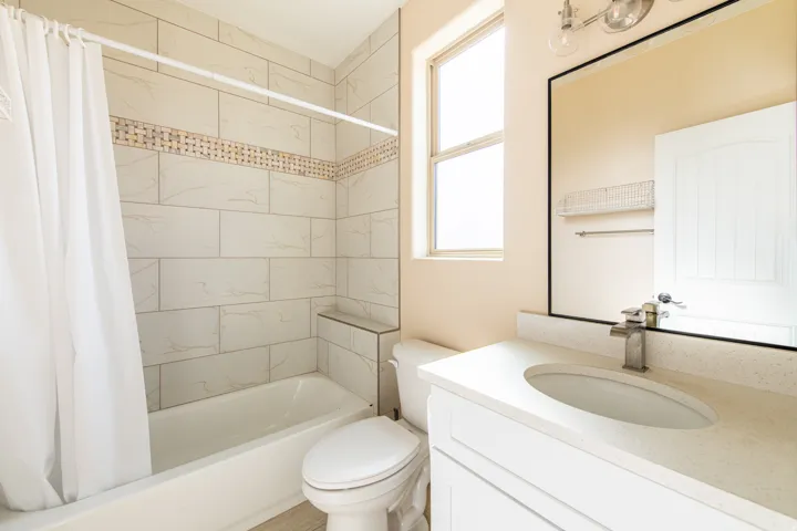 Full bath with shower / tub combo with curtain and vanity