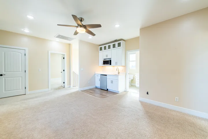 Unfurnished living room featuring light carpet, ceiling fan, and recessed lighting